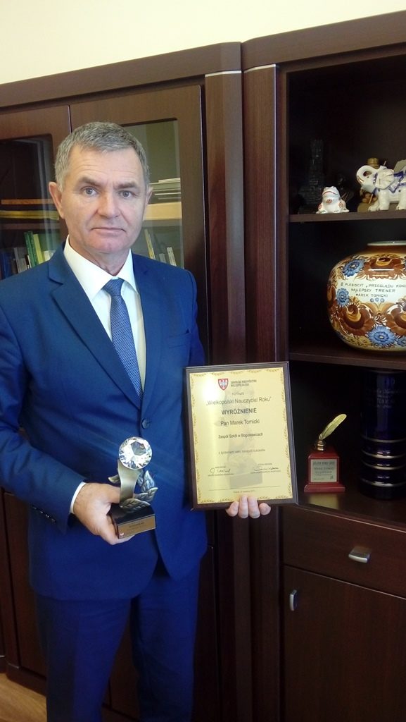 dr Marek Tomicki, dyrektor Szkoły Podstawowej w Bogusławicach wraz z dyplomem i statuetką.